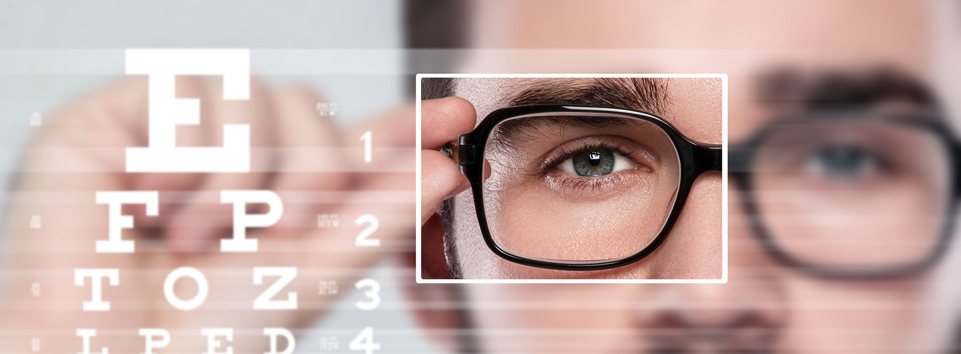 An adult male in glasses, looking directly at the camera through a magnifying glass.