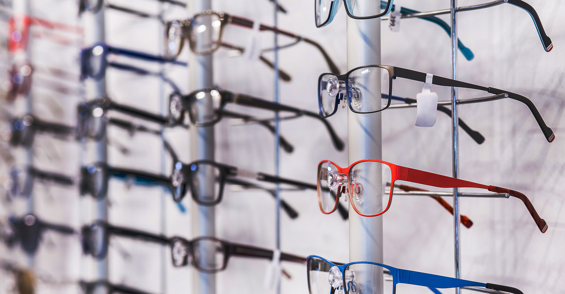 A collection of eyeglasses displayed in a store, with a focus on the variety of colors and styles available.