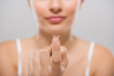 A close-up image of a person s hand holding a clear, circular object with a focus on the item being held.